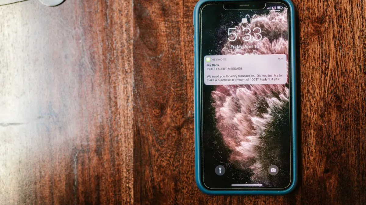Smartphone displaying a bank text-message alert.