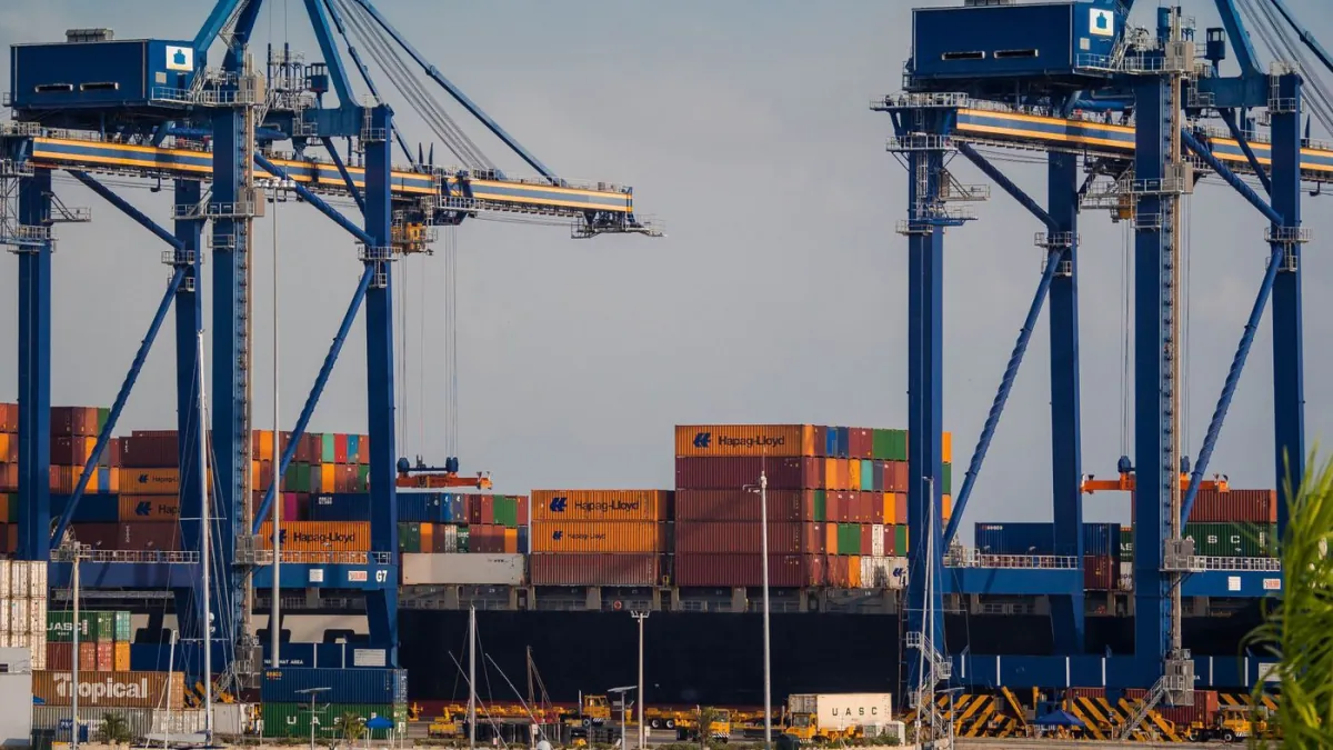 Container cranes and freight containers at a shipping port.