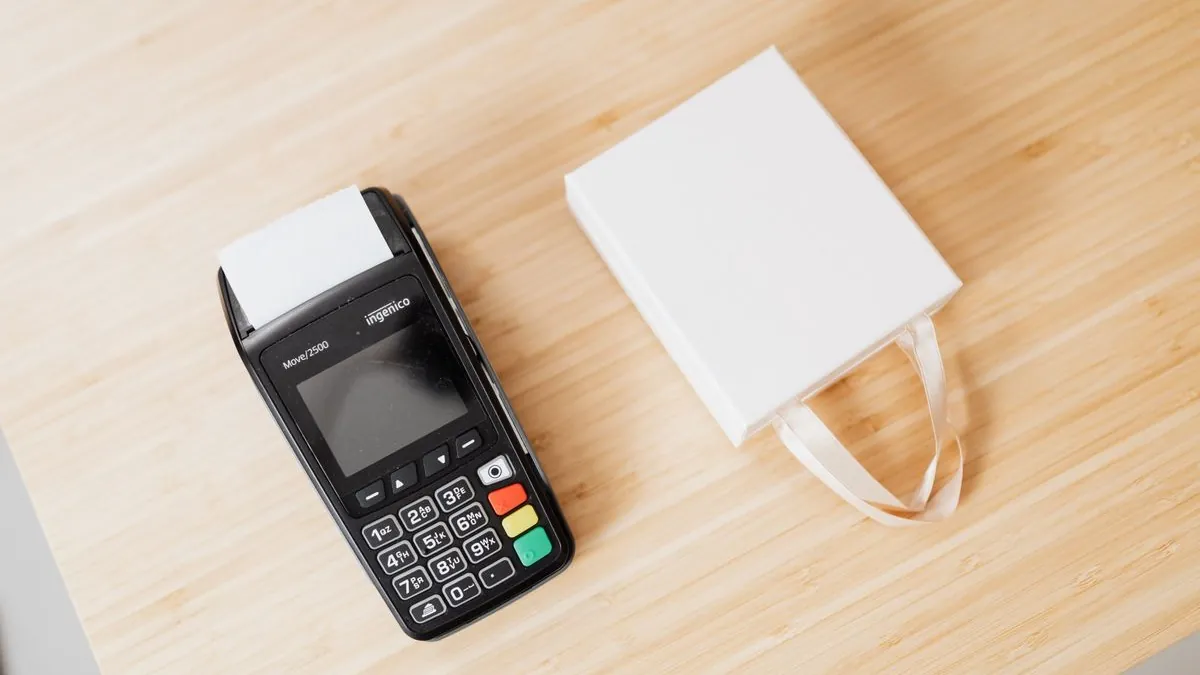 M-Pesa payment terminal and printed transaction receipt on a counter.