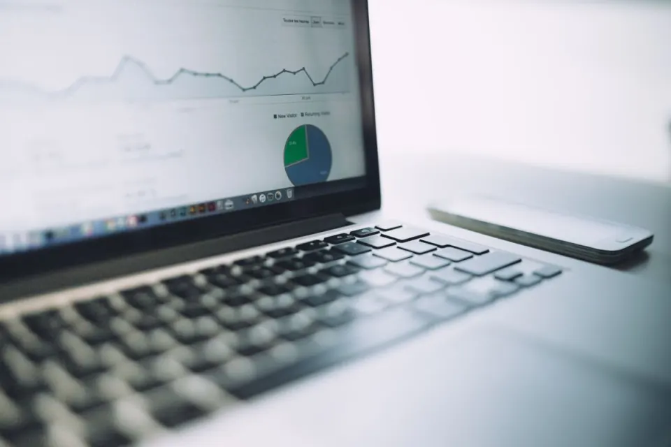 Laptop displaying analytics charts beside a planning notebook